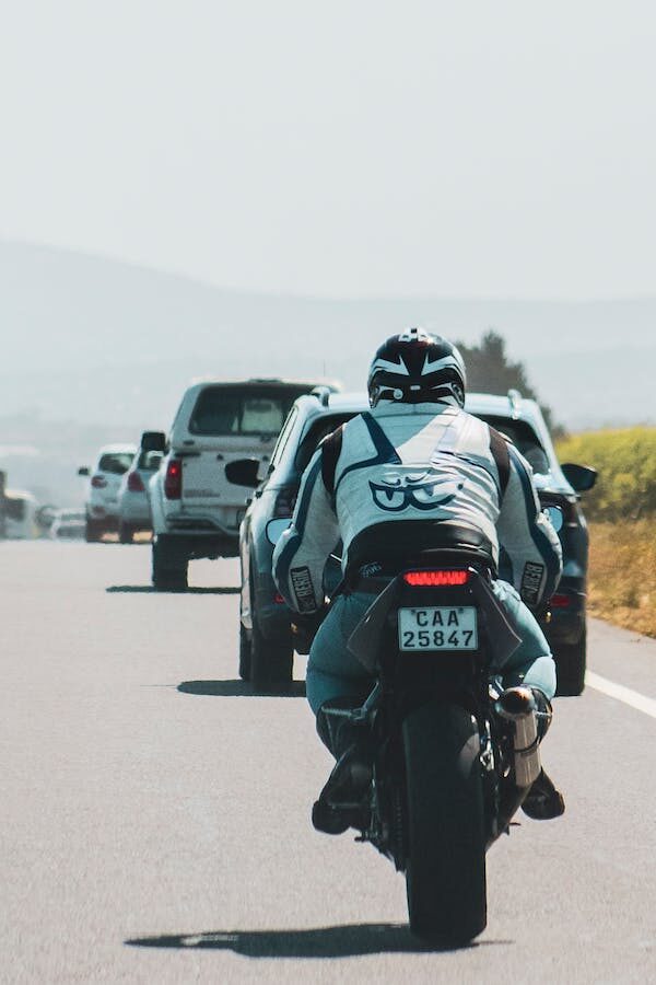 Man riding motorcycle on the road with other cars